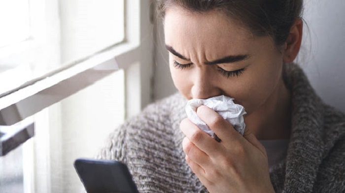 holding tissues to nose - علت خون دماغ شدن از یک سوراخ بینی بزرگسالان